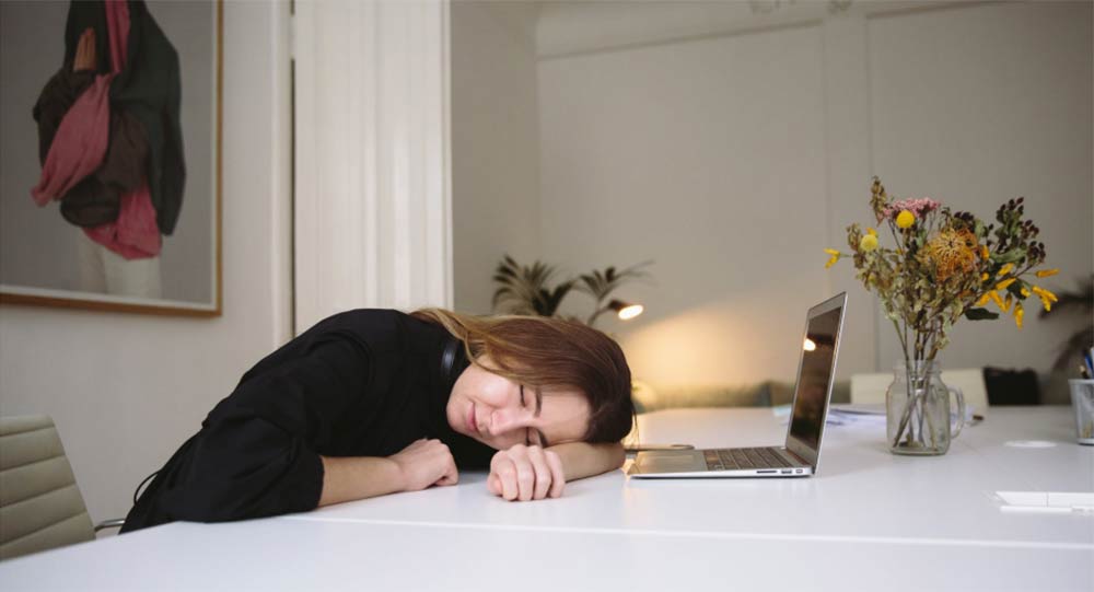 A youg woman asleep at the dining room table